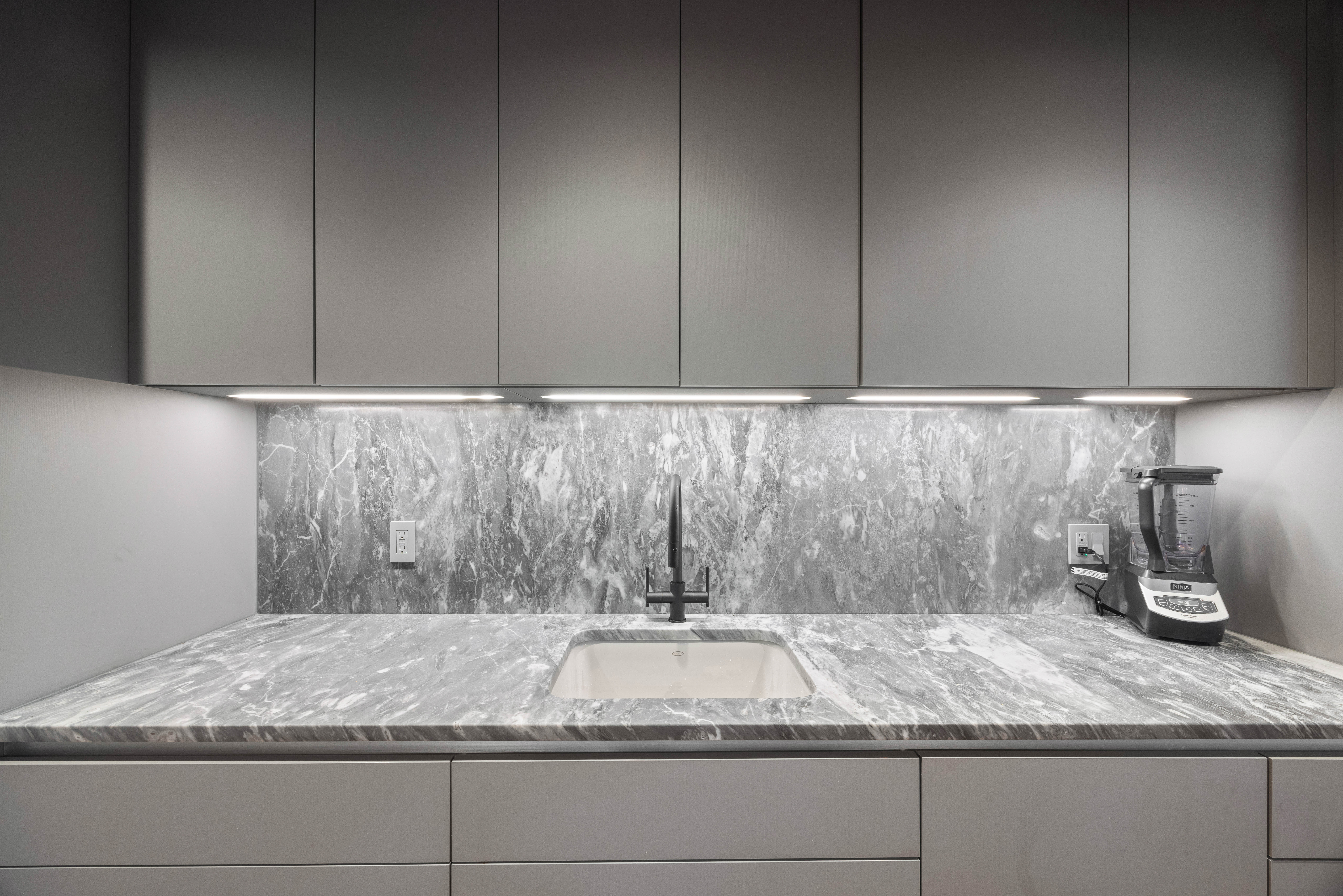 547 West 47th Street, Unit 509 Manhattan, NY 10036 - Photo 9 of 29 a bathroom with a granite countertop sink and white cabinets