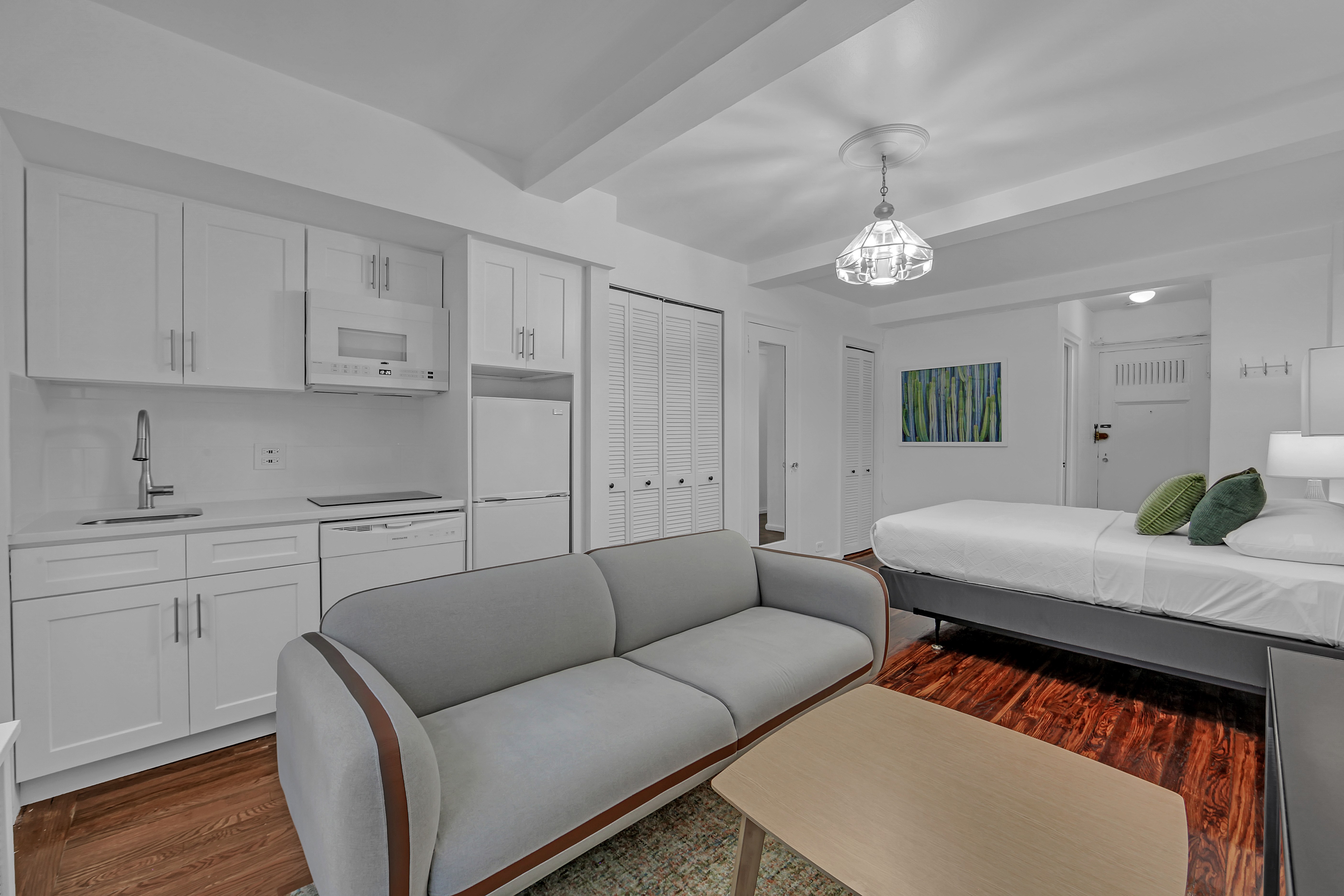 45 Tudor City Place, Unit 1902 Manhattan, NY 10017 - Photo 6 of 19 a living room with furniture a chandelier and a rug