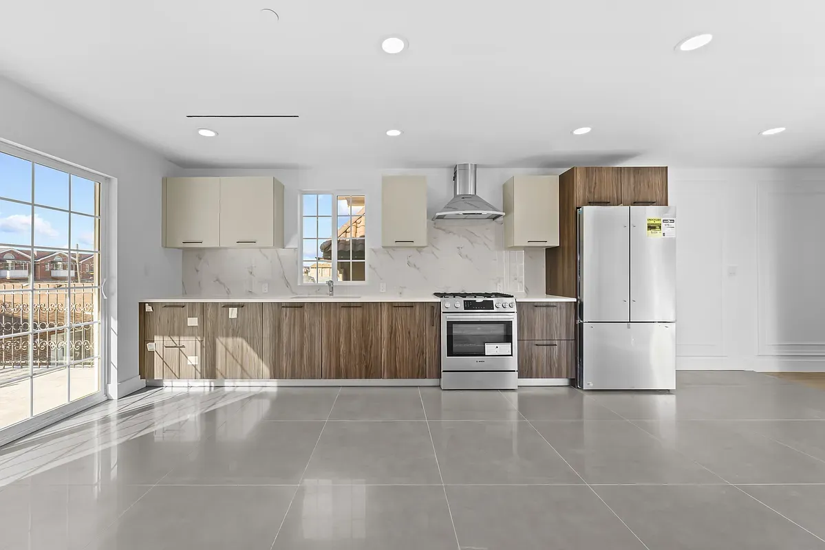 a large kitchen with stainless steel appliances a refrigerator and a stove top oven