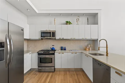 a kitchen with a sink and steel appliances