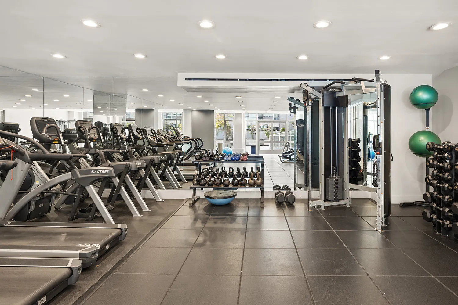a room with gym equipment and lots of mirrors