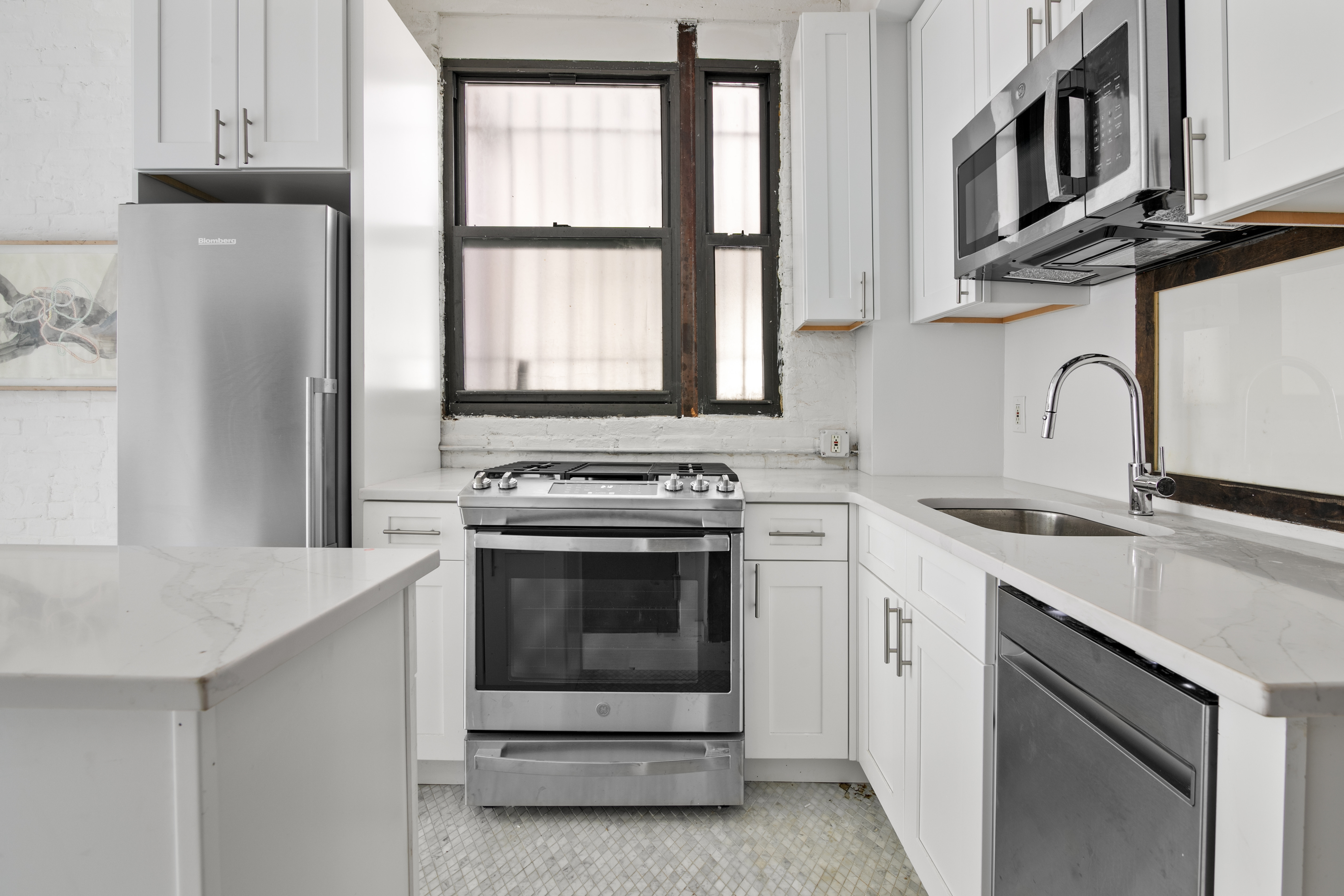 305 East 4th Street, Unit GARDEN Manhattan, NY 10009 - Photo 5 of 8 a kitchen with stainless steel appliances granite countertop a stove and a sink