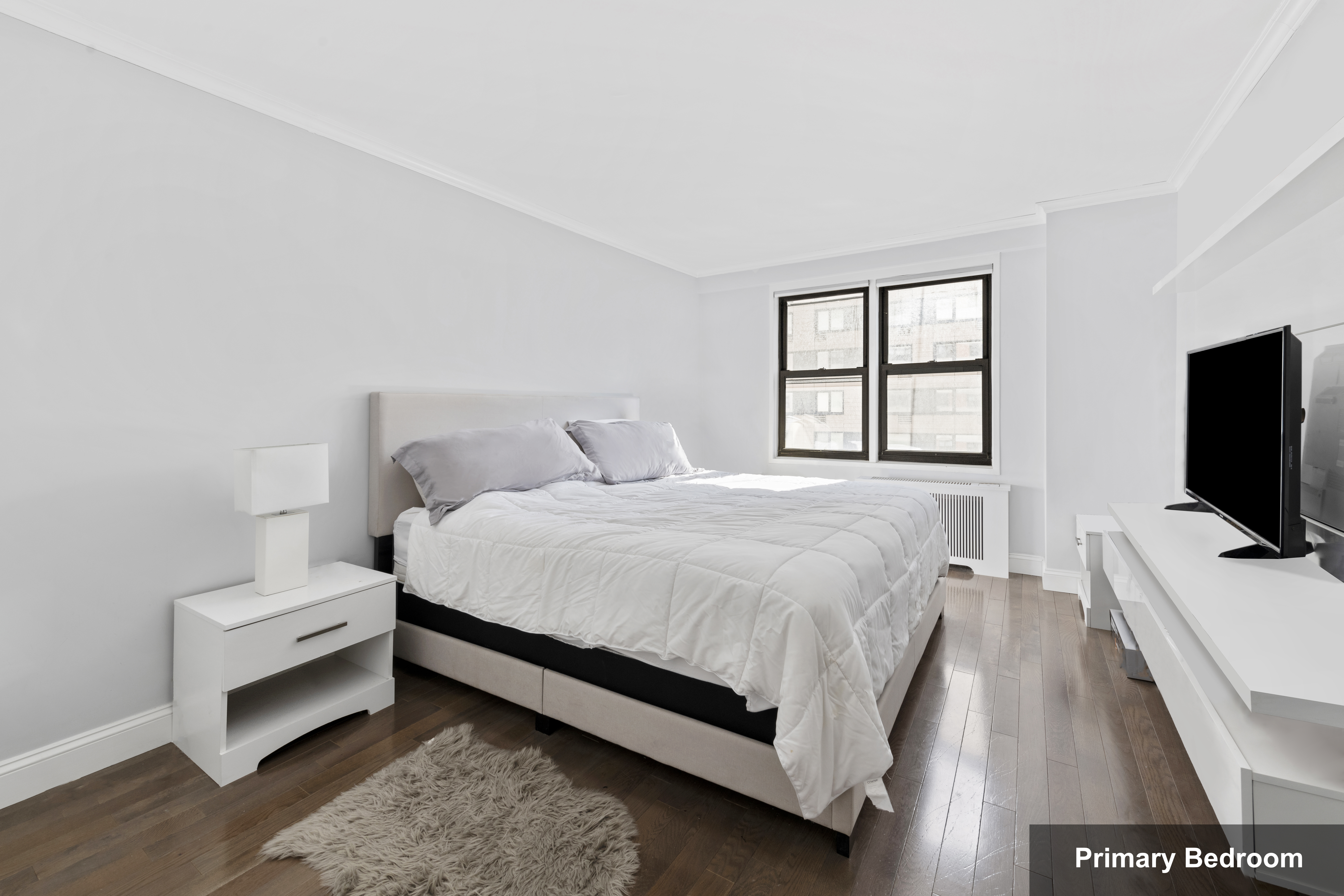 333 East 34th Street, Unit 10H Manhattan, NY 10016 - Photo 9 of 16 a bedroom with a bed and a flat tv screen on a dresser