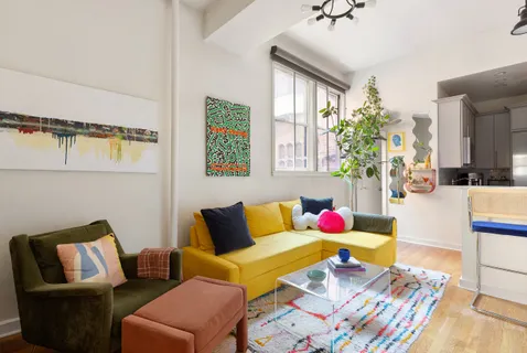 a living room with furniture wooden floor and painting on the wall
