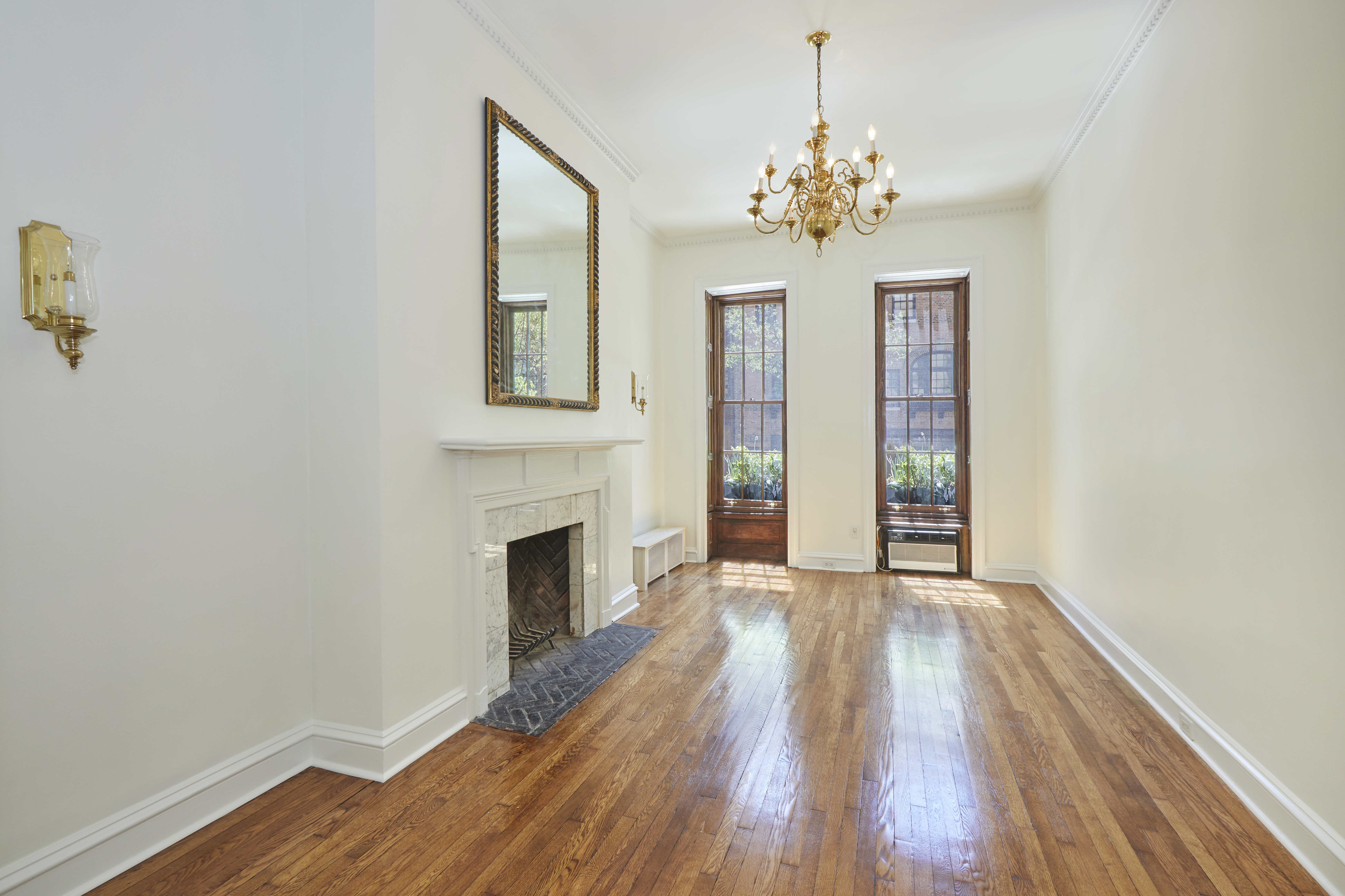 157 East 75th Street, Unit 1E Manhattan, NY 10021 - Photo 11 of 21 a view of a livingroom with wooden floor and a chandelier