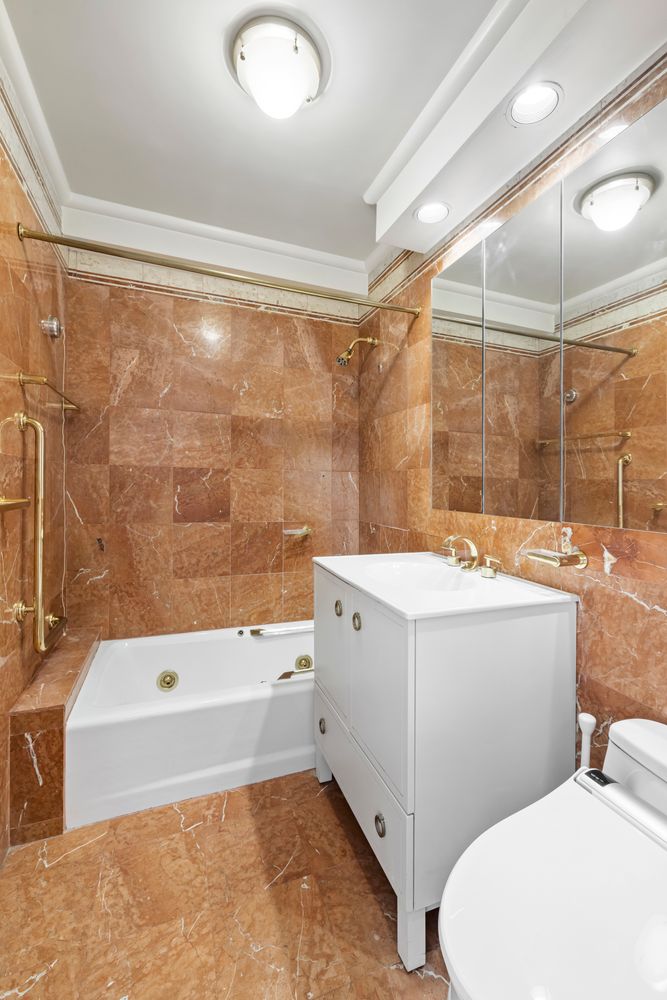 40 East 80th Street, Unit 25A Manhattan, NY 10075 - Photo 9 of 18 a bathroom with a sink and mirror with bathtub