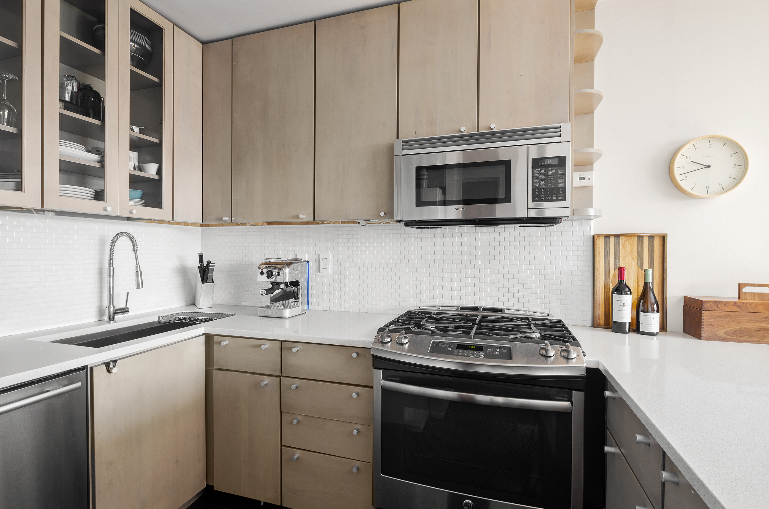 181 7th Avenue, Unit 11A Manhattan, NY 10011 - Photo 6 of 13 a kitchen with stainless steel appliances granite countertop a stove and a microwave