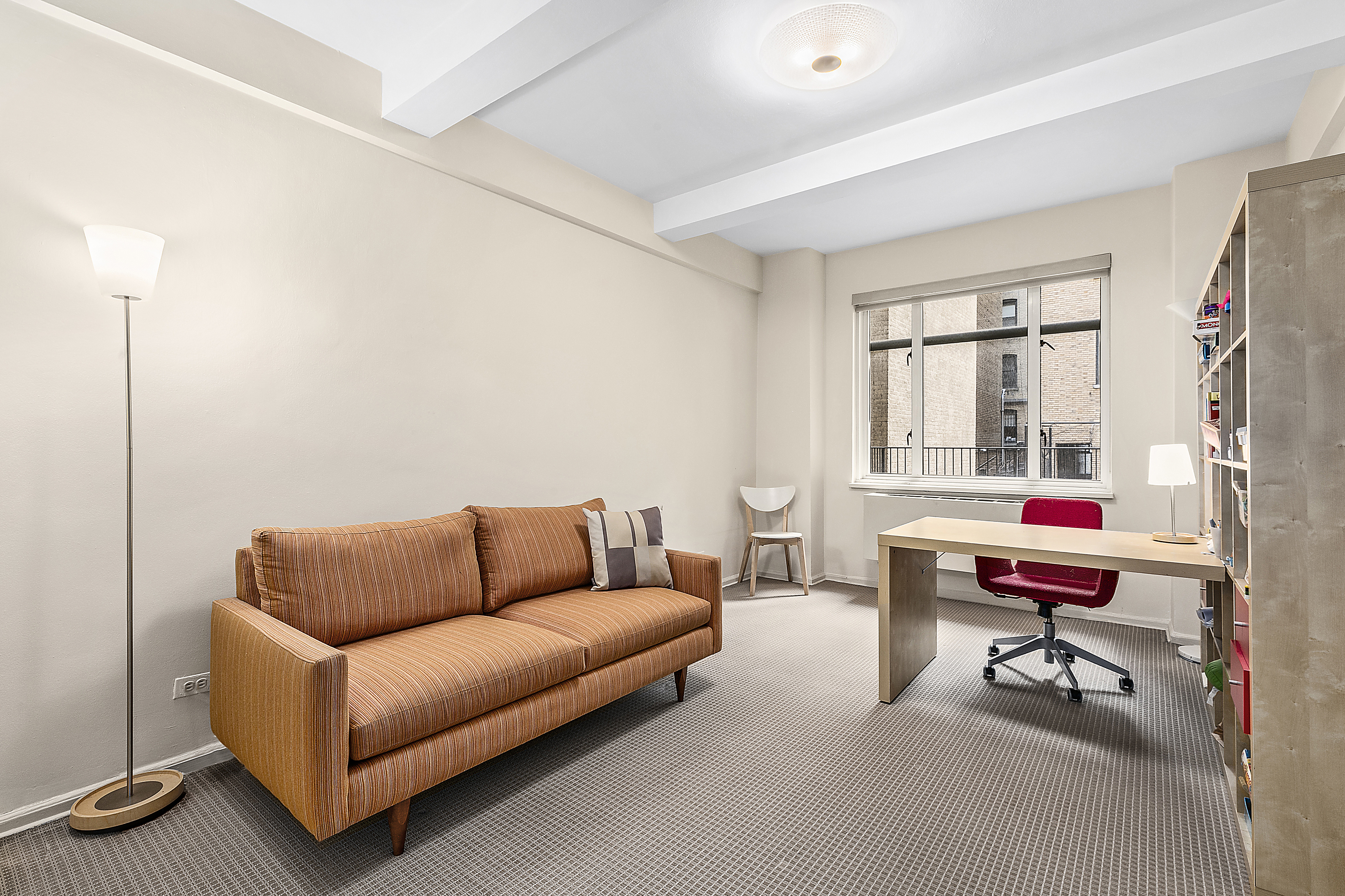 65 East 76th Street, Unit 1C Manhattan, NY 10021 - Photo 4 of 6 a living room with furniture a wooden floor and a large window