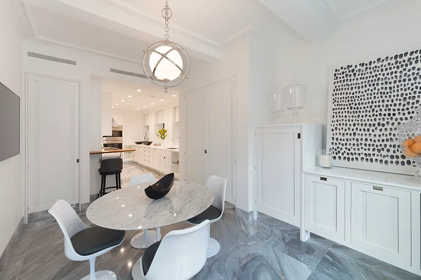 a dining room with wooden floor furniture and kitchen view