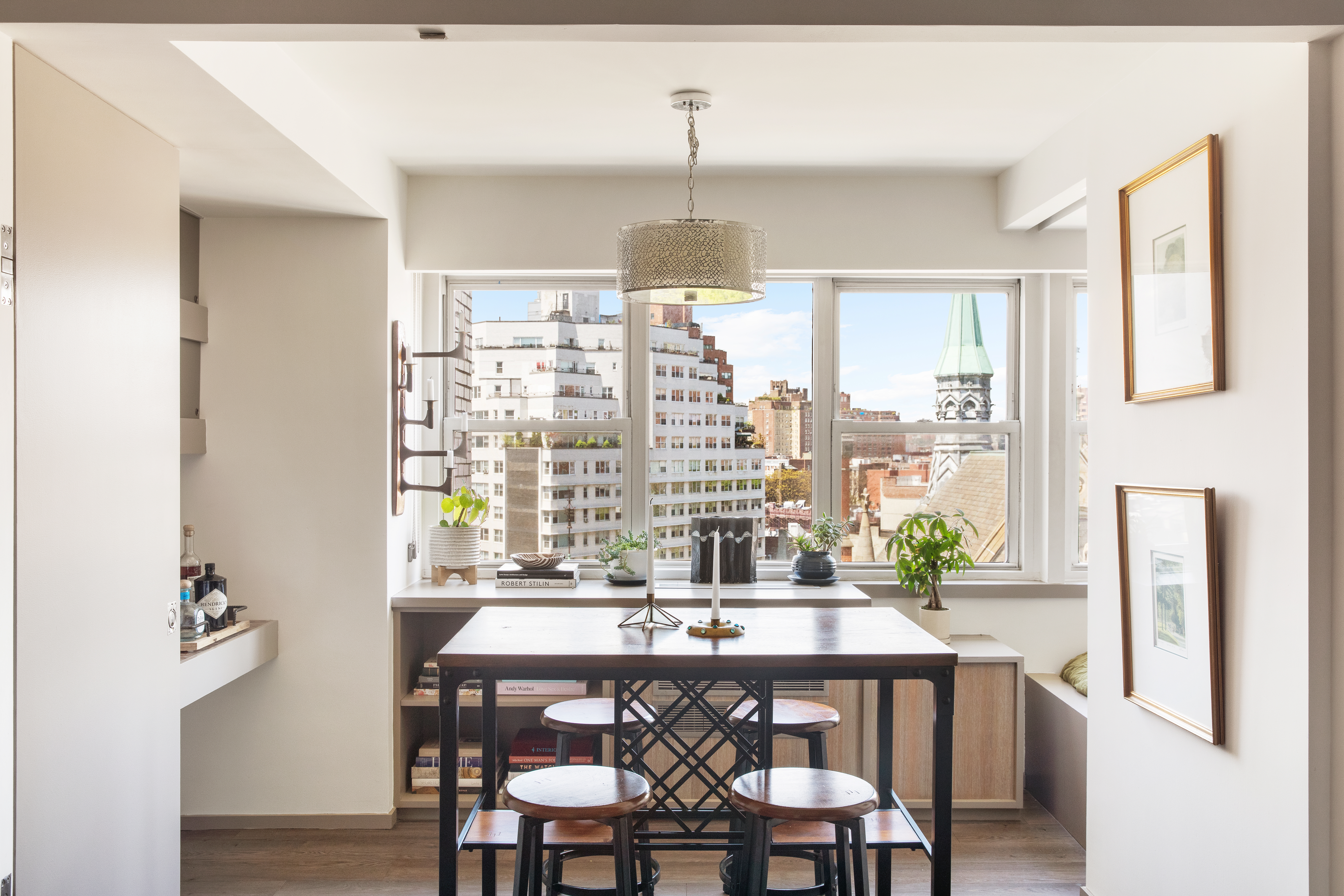 69 West 9th Street, Unit 11CDE Manhattan, NY 10011 - Photo 2 of 9 a dining room with wooden floor a chandelier a wooden table and chairs