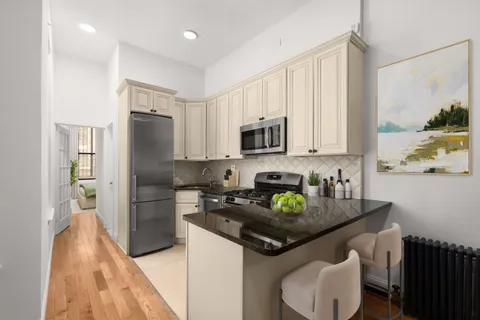 a kitchen with stainless steel appliances granite countertop a refrigerator sink and stove