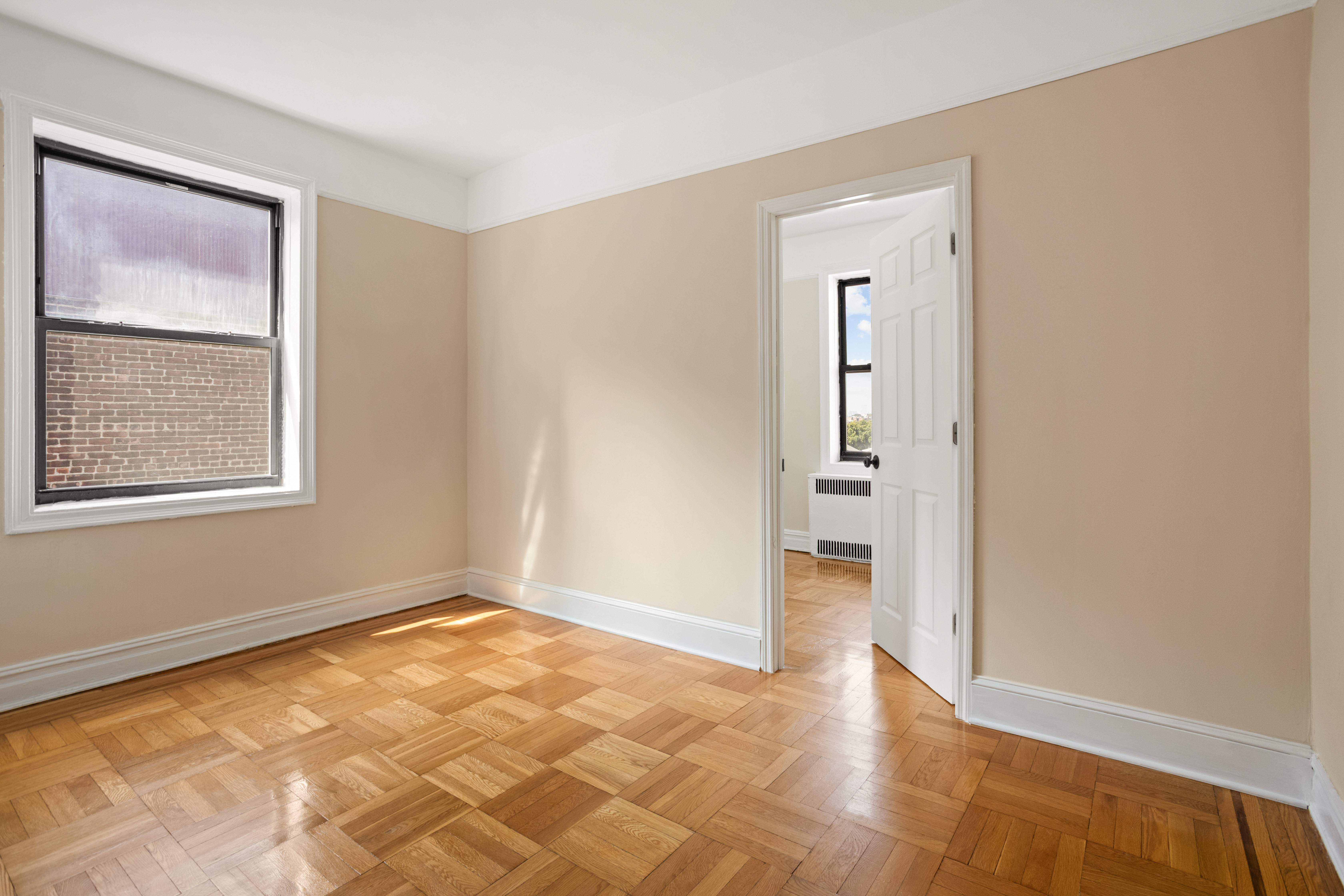 35-30 73rd Street Queens, NY 11372 - Photo 4 of 11 a view of an empty room with window and wooden floor