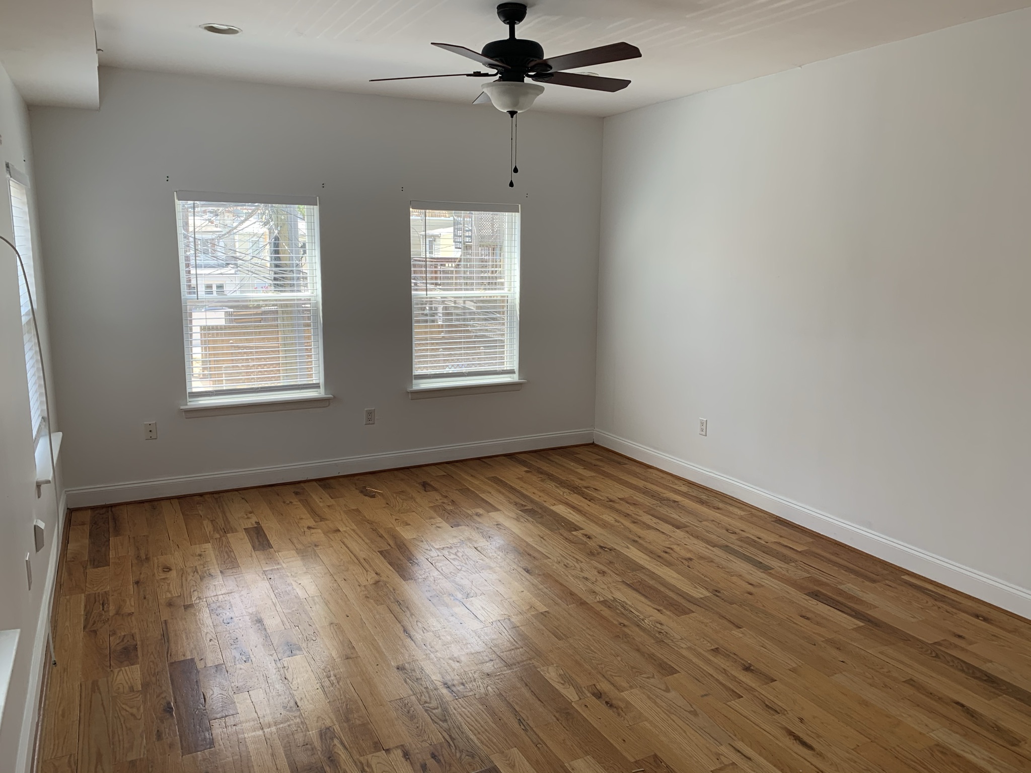 101 West Clement Street Baltimore, MD 21230 - Photo 3 of 7 an empty room with wooden floor chandelier fan and windows