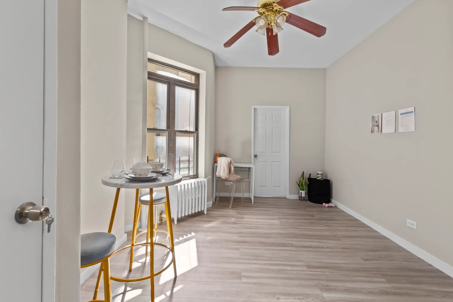 a view of a livingroom with a dinning area hardwood floor a ceiling fan and windows