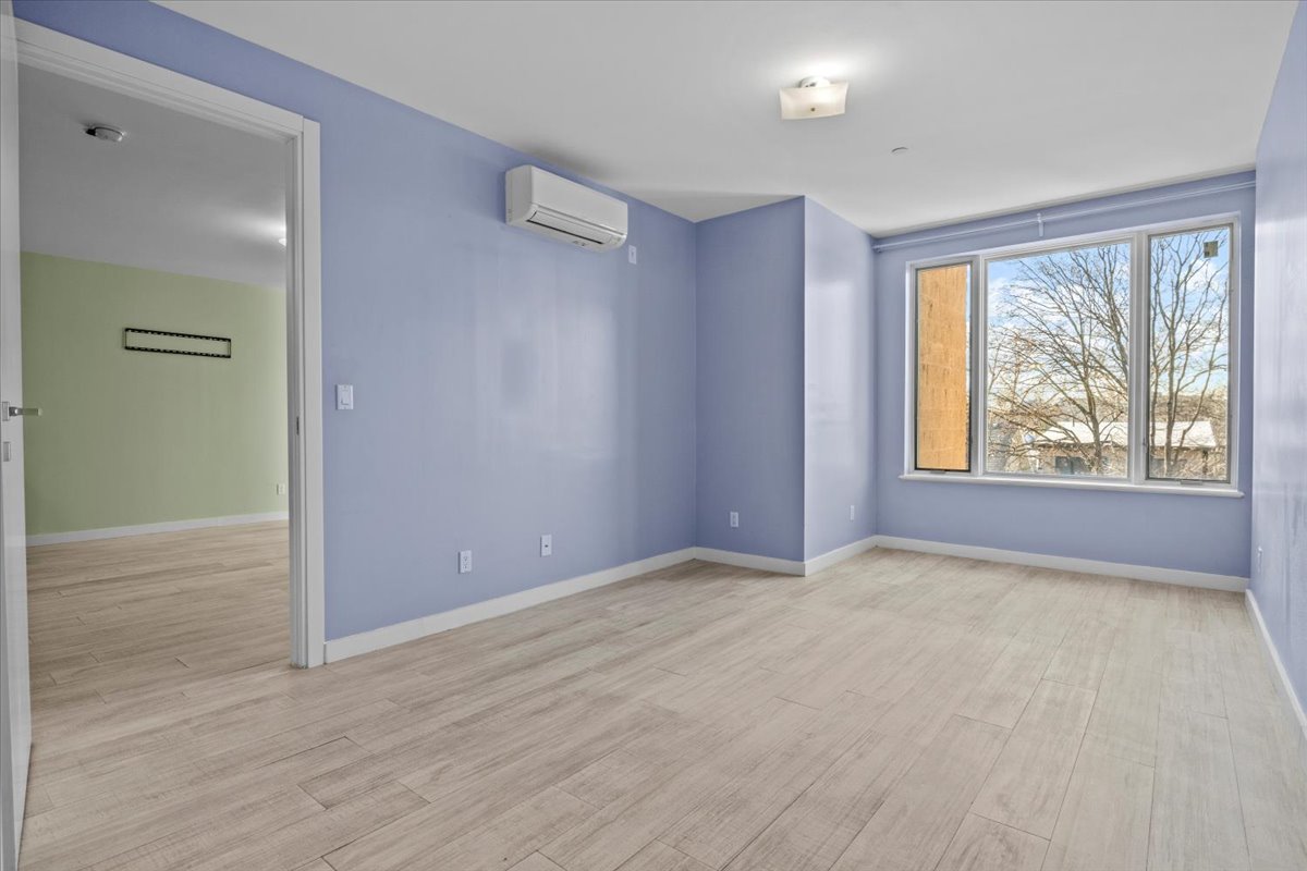 1972 Ocean Avenue, Unit 4A Brooklyn, NY 11230 - Photo 12 of 18 an empty room with wooden floor and windows