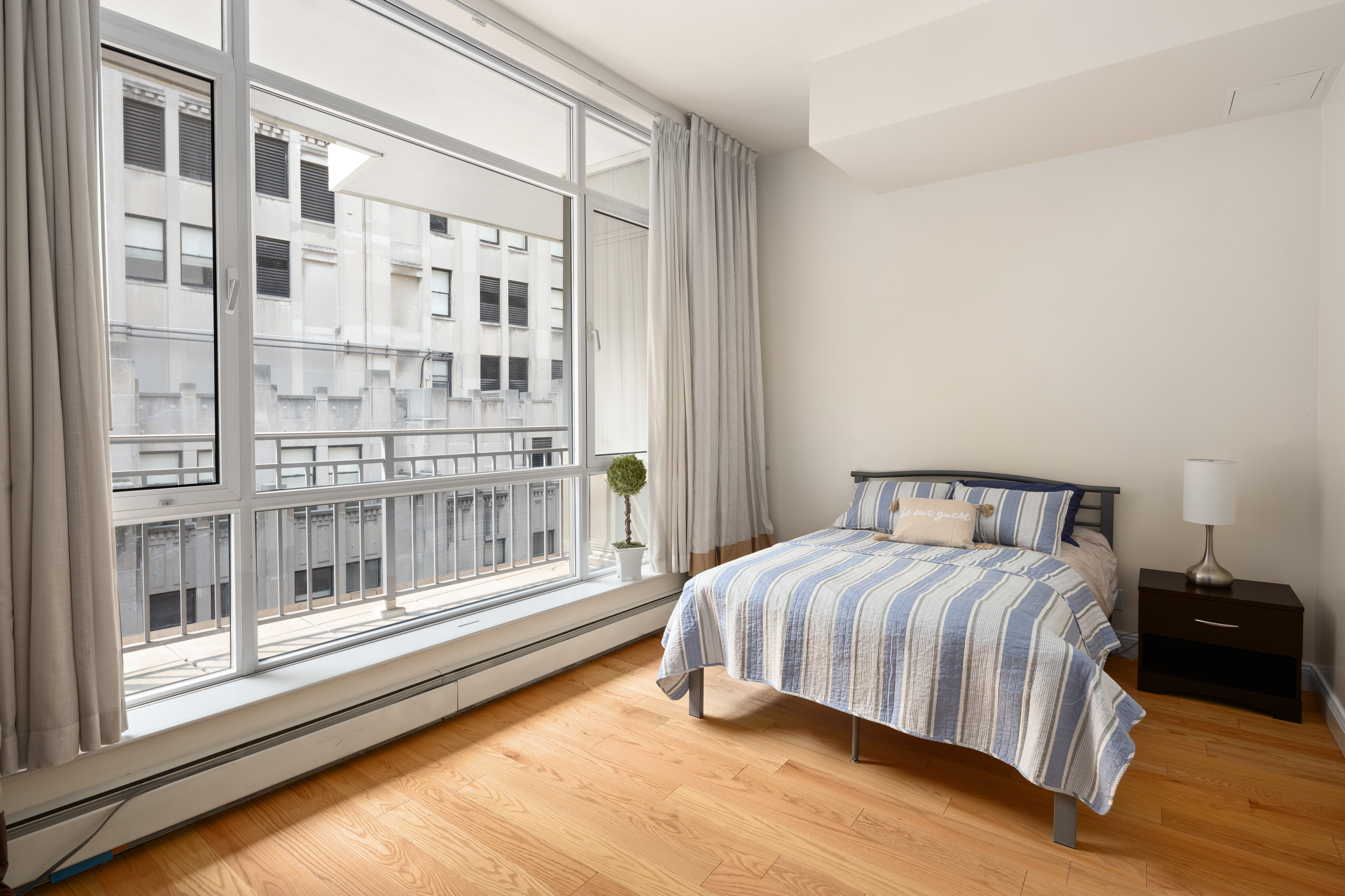 59 John Street, Unit PH1 Manhattan, NY 10038 - Photo 9 of 15 a bedroom with a bed and a large window