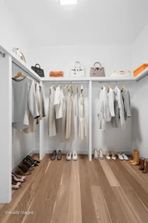 a view of walk in closet with clothes and shoes