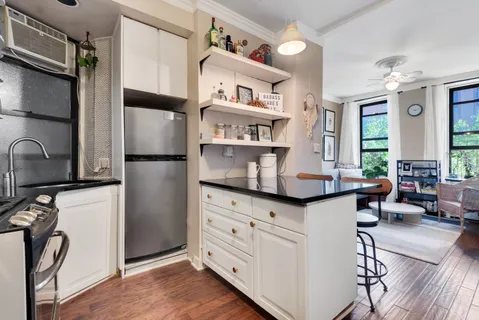 a kitchen with stainless steel appliances a stove a refrigerator a center island and furniture