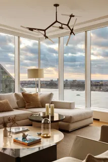 a living room with furniture and a large window with balcony view
