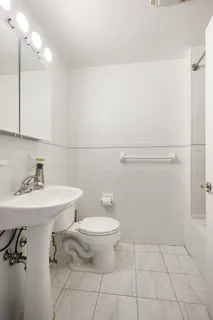 a bathroom with a toilet a sink and mirror