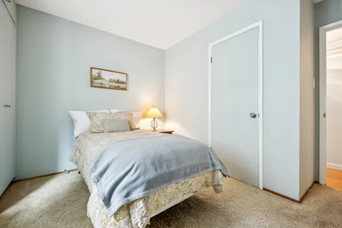 a bedroom with a bed and painting on the wall