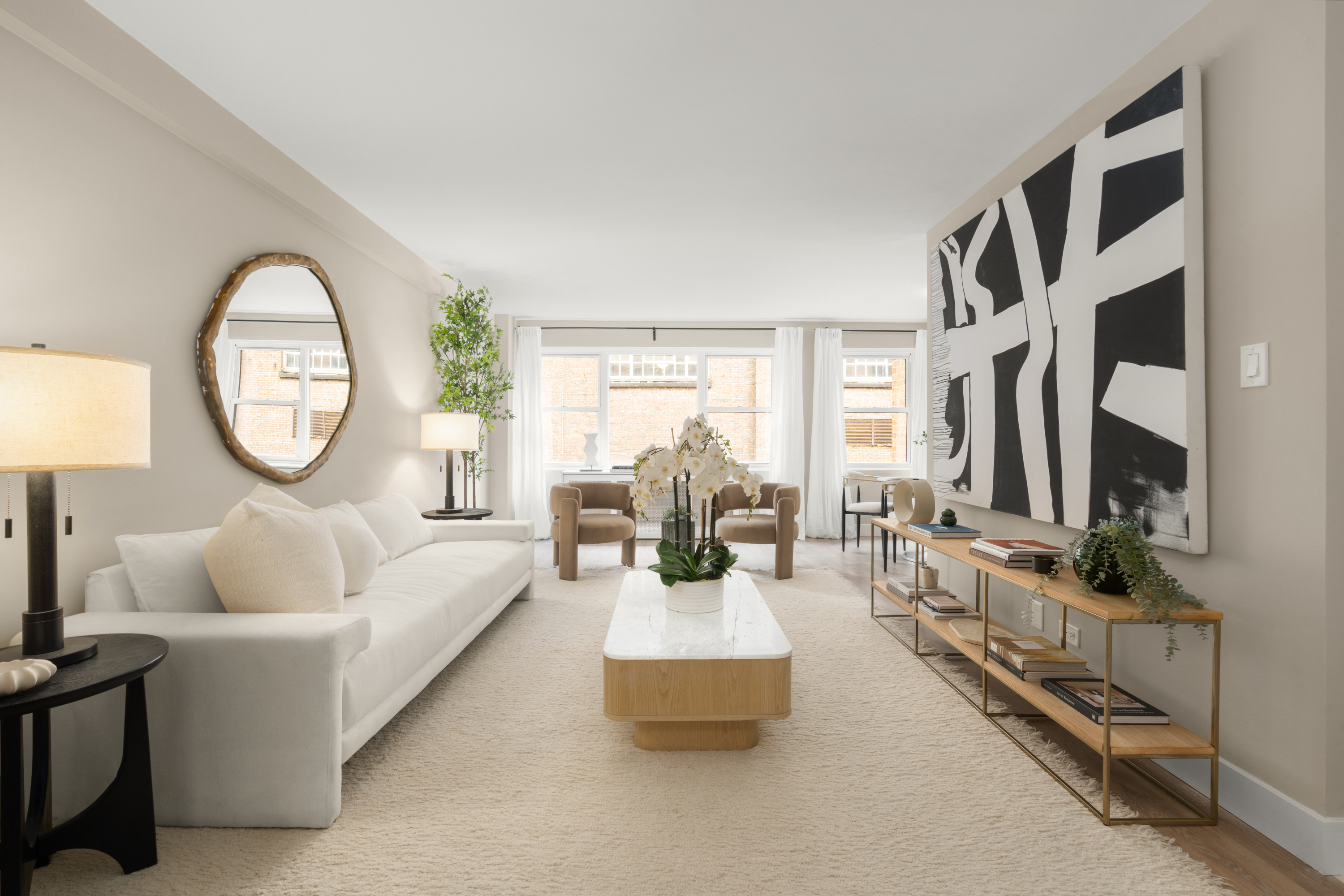 347 East 53rd Street, Unit 2C Manhattan, NY 10022 - Photo 2 of 18 a living room with furniture a mirror and a fireplace