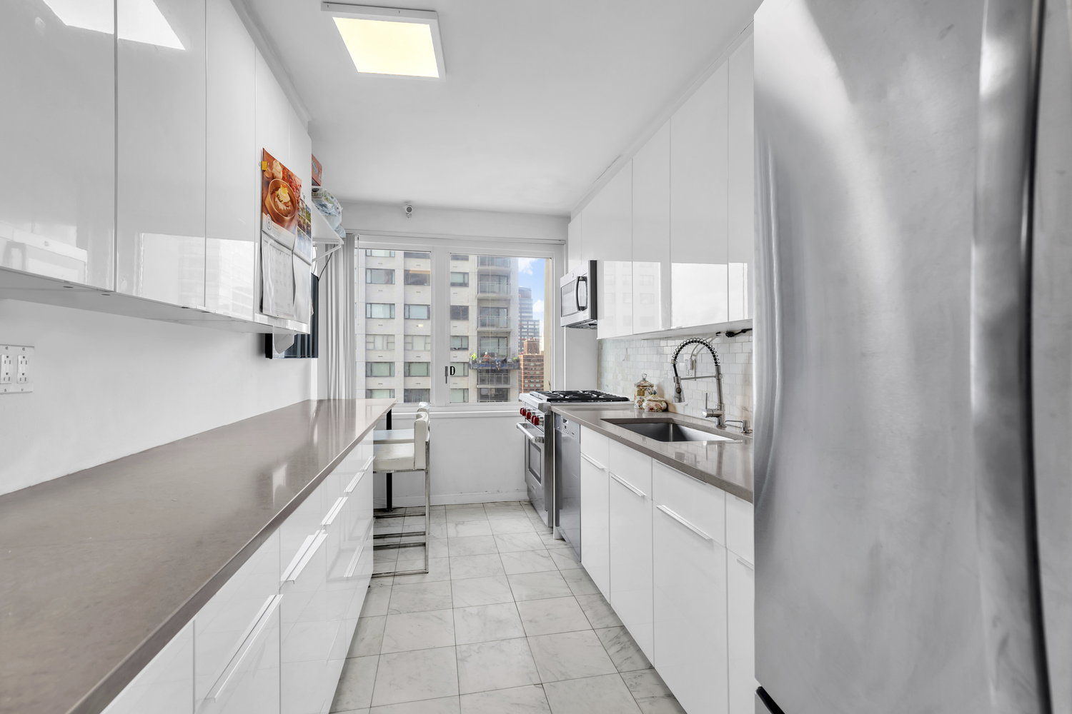 300 East 59th Street, Unit 2601 Manhattan, NY 10022 - Photo 4 of 12 a kitchen with a sink stove and cabinets