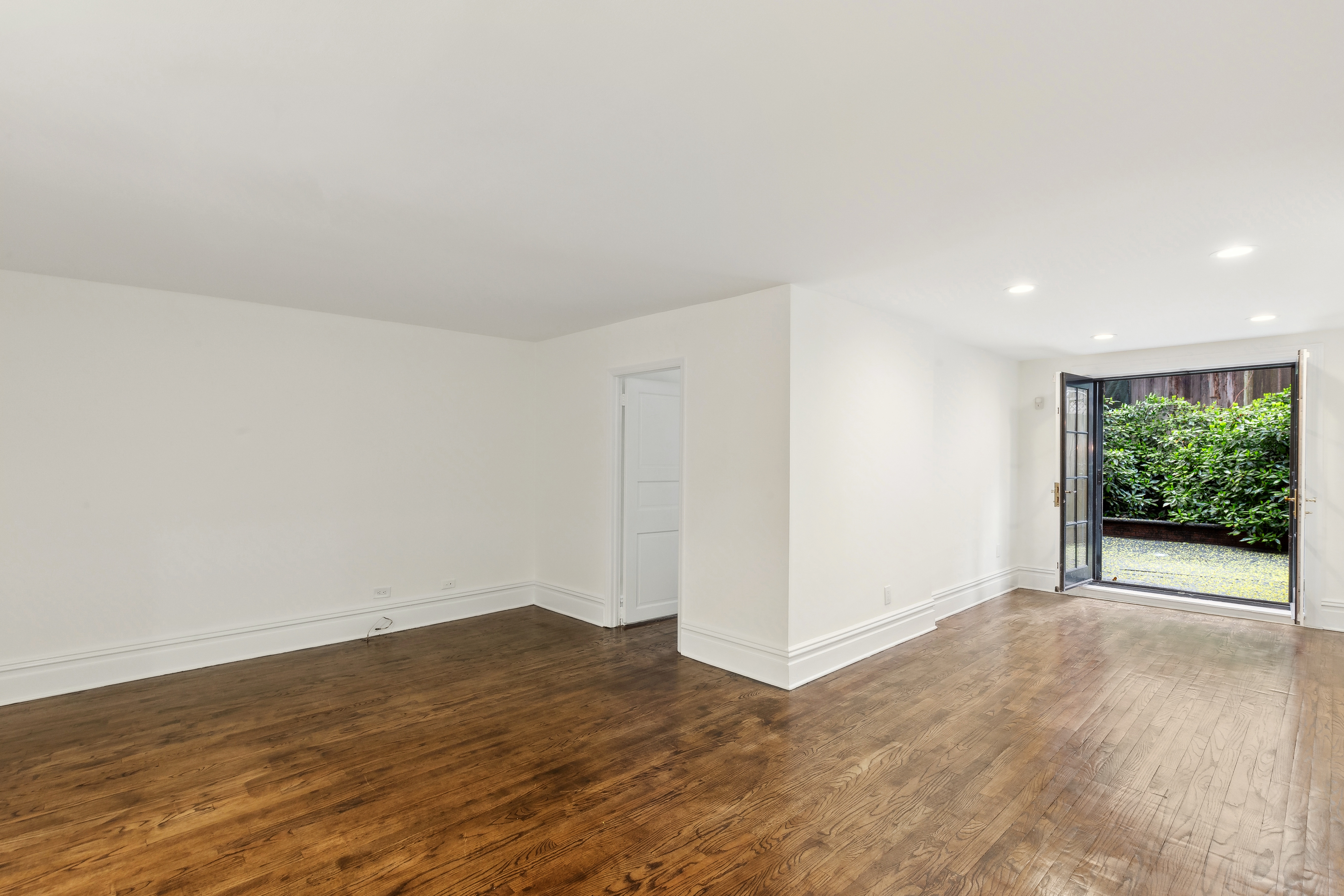 128 East 65th Street Manhattan, NY 10065 - Photo 3 of 10 a view of an empty room with wooden floor and a window