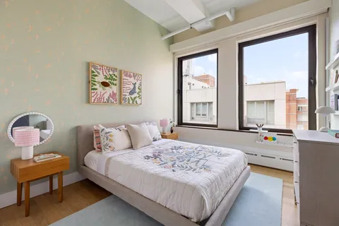 a bedroom with a bed and a large window