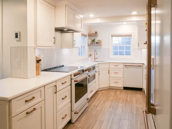 a kitchen with stainless steel appliances white cabinets and wooden floors