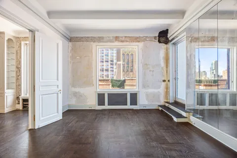 an empty room with cabinet and mirrors
