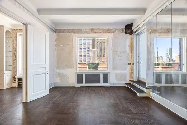 an empty room with cabinet and mirrors