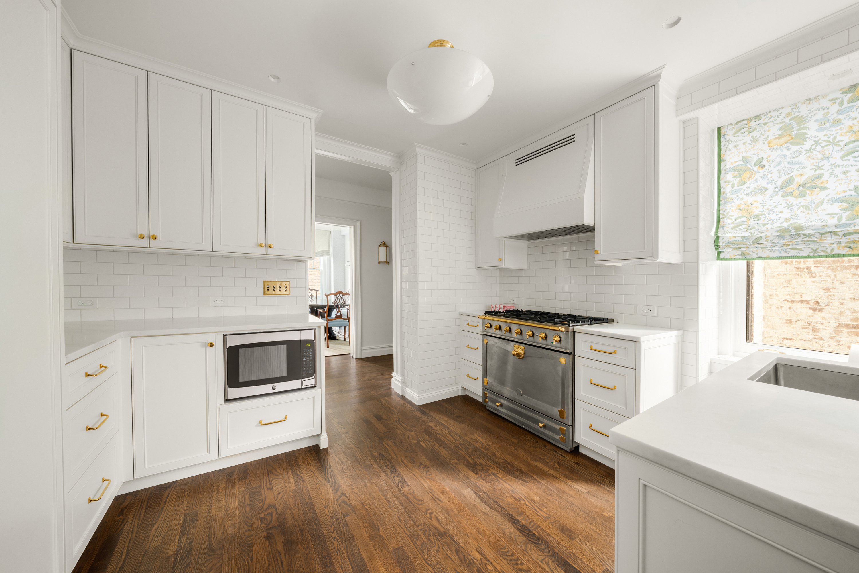 108 East 82nd Street, Unit 7C Manhattan, NY 10028 - Photo 2 of 9 a kitchen with granite countertop white cabinets and white appliances