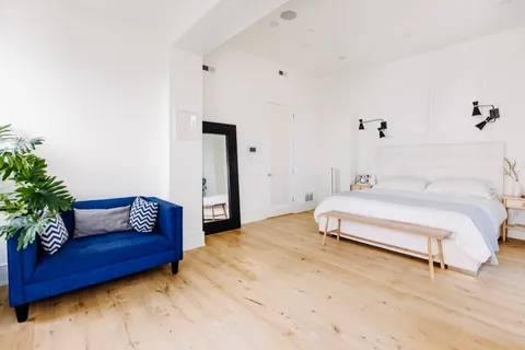 a bedroom with a bed and a potted plant