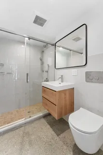 a bathroom with a sink a toilet and shower