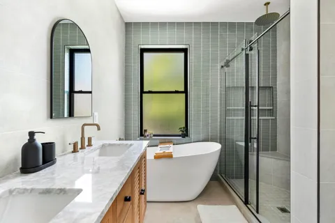 a bathroom with a granite countertop sink mirror and bathtub