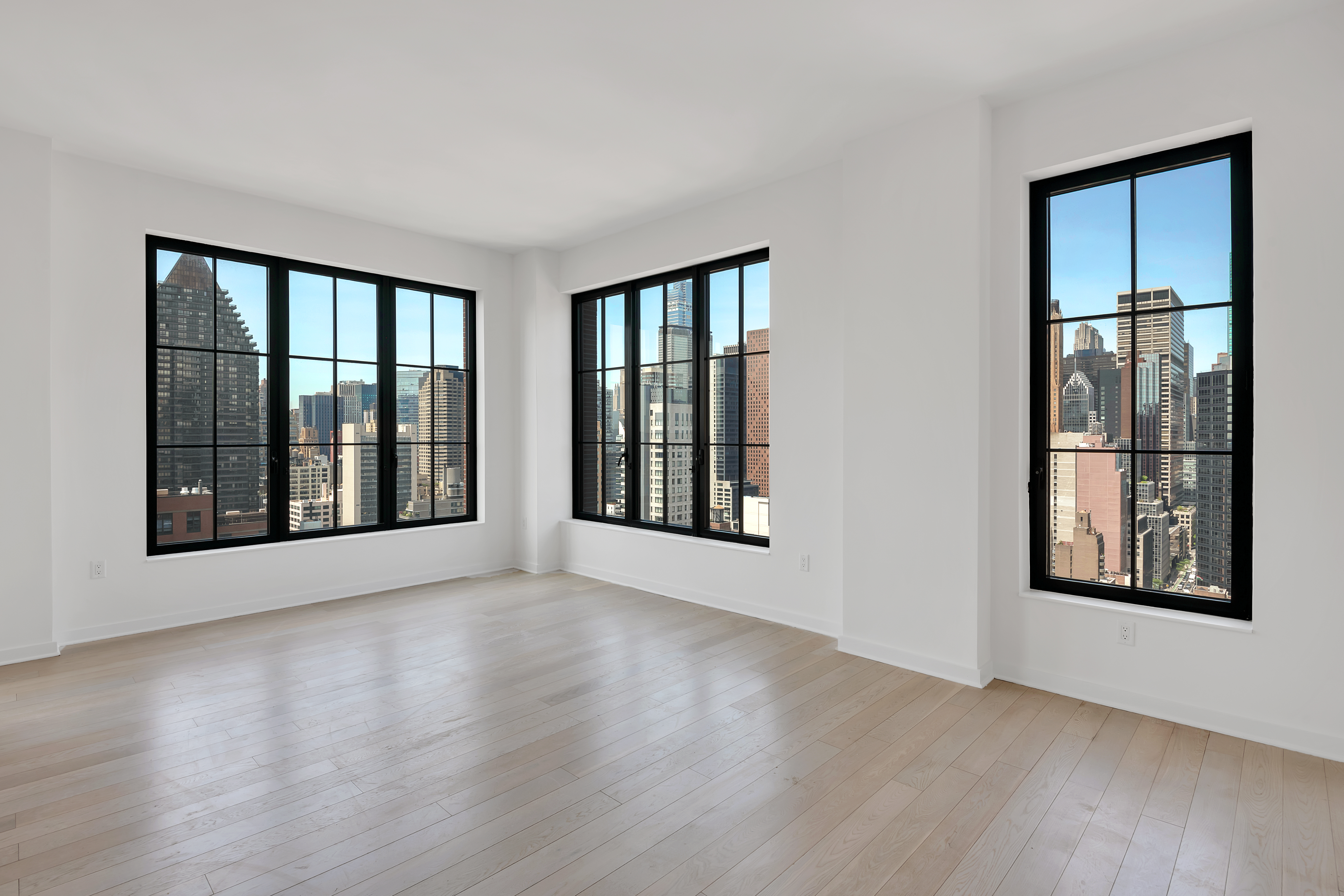 959 1st Avenue, Unit 25H Manhattan, NY 10022 - Photo 2 of 18 a view of an empty room with wooden floor and a window