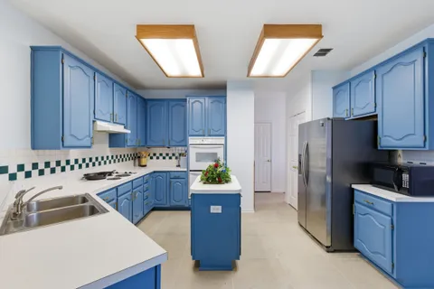 a kitchen with a refrigerator and a stove top oven