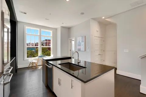 a kitchen with granite countertop a sink and a stove