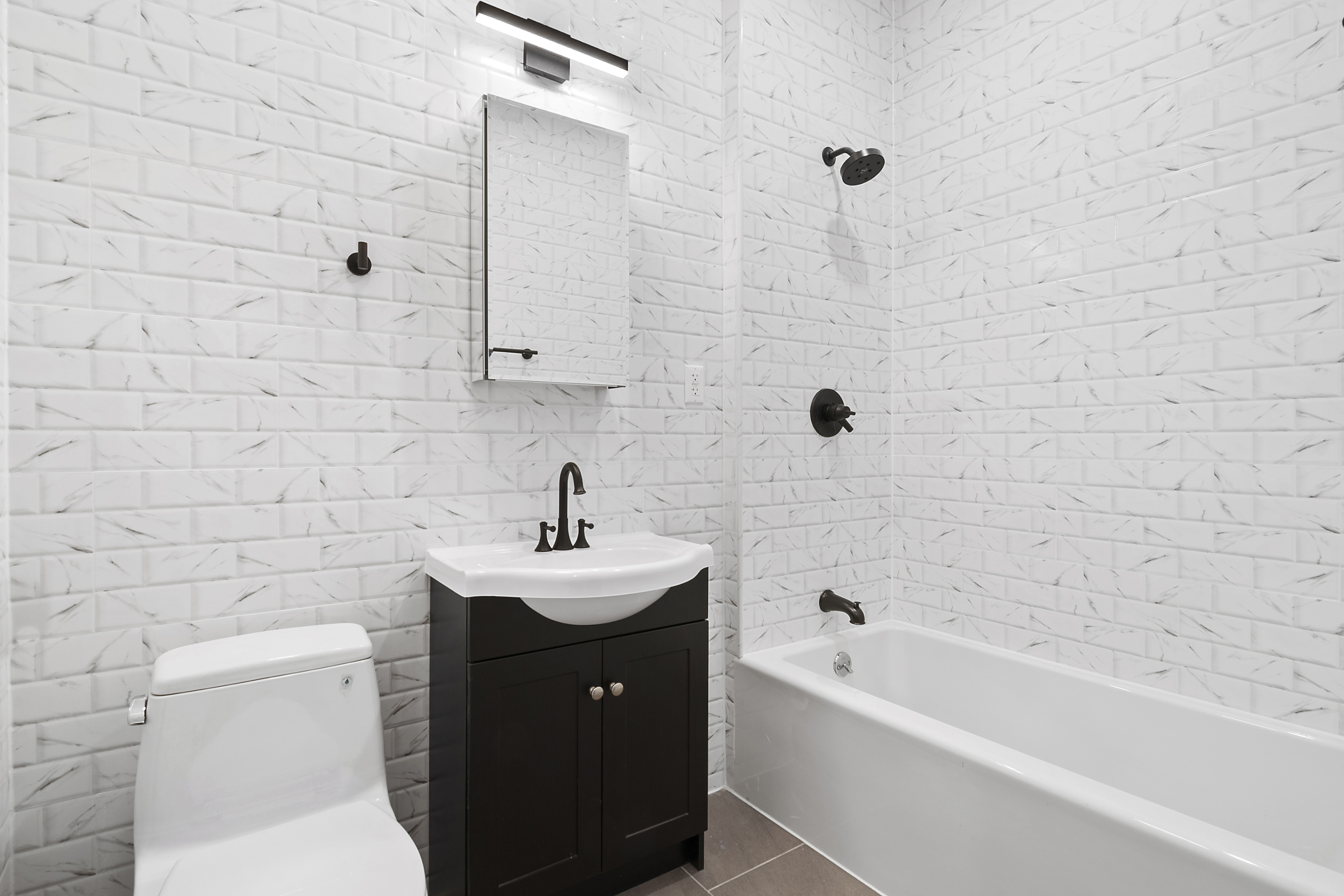 48 Cornelia Street, Unit 3C Brooklyn, NY 11221 - Photo 2 of 4 a bathroom with a sink a toilet and shower