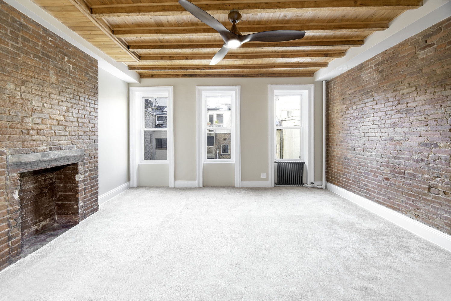 21 Downing Street, Unit 4 Manhattan, NY 10014 - Photo 2 of 6 a view of an empty room with a fireplace and a window