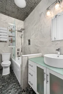 a bathroom with a sink a toilet and shower