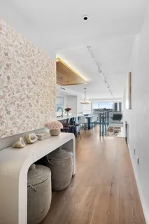a living room with couches and kitchen view with wooden floor