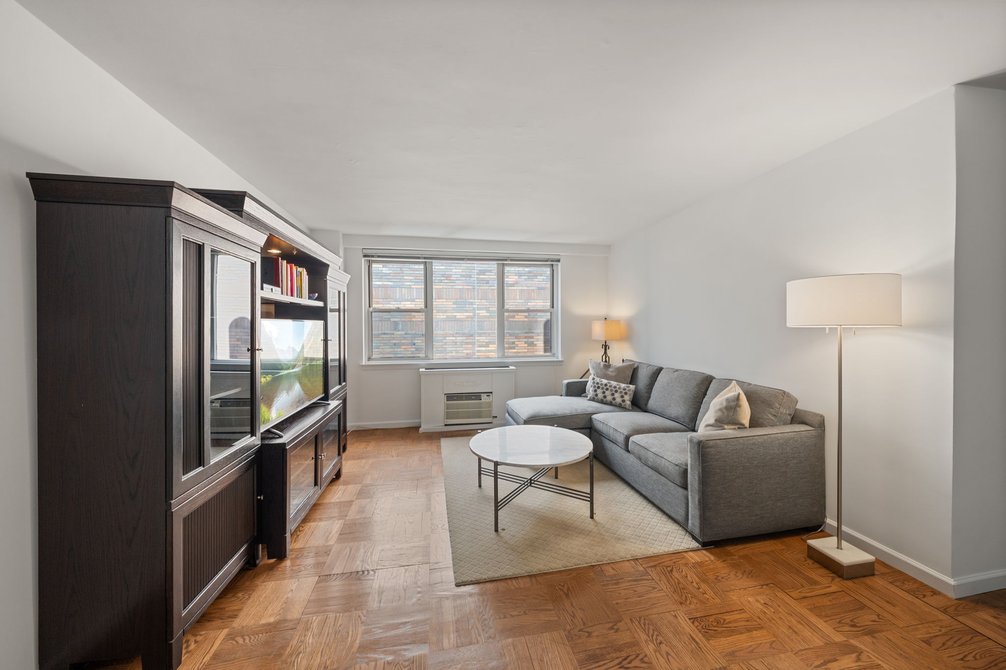 139 East 33rd Street, Unit 11L Manhattan, NY 10016 - Photo 2 of 15 a living room with furniture and a flat screen tv