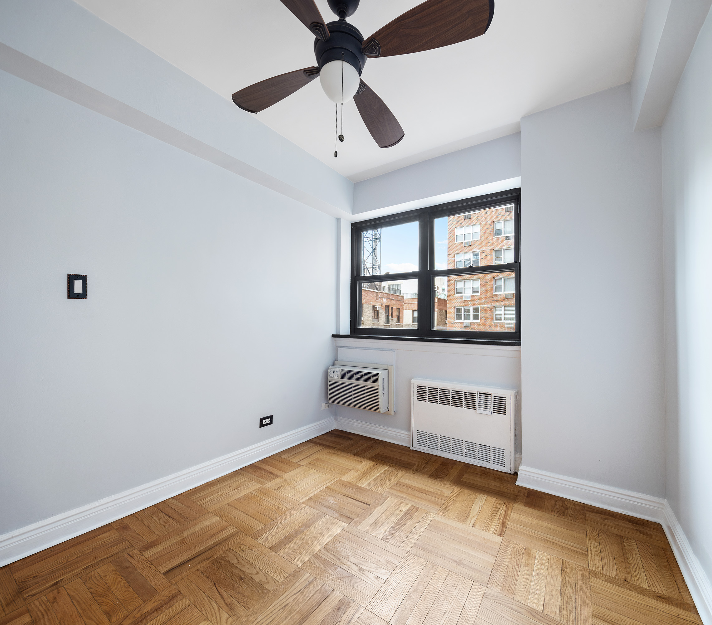 181 East 73rd Street, Unit 9G Manhattan, NY 10021 - Photo 13 of 17 a view of an empty room with a window and a ceiling fan