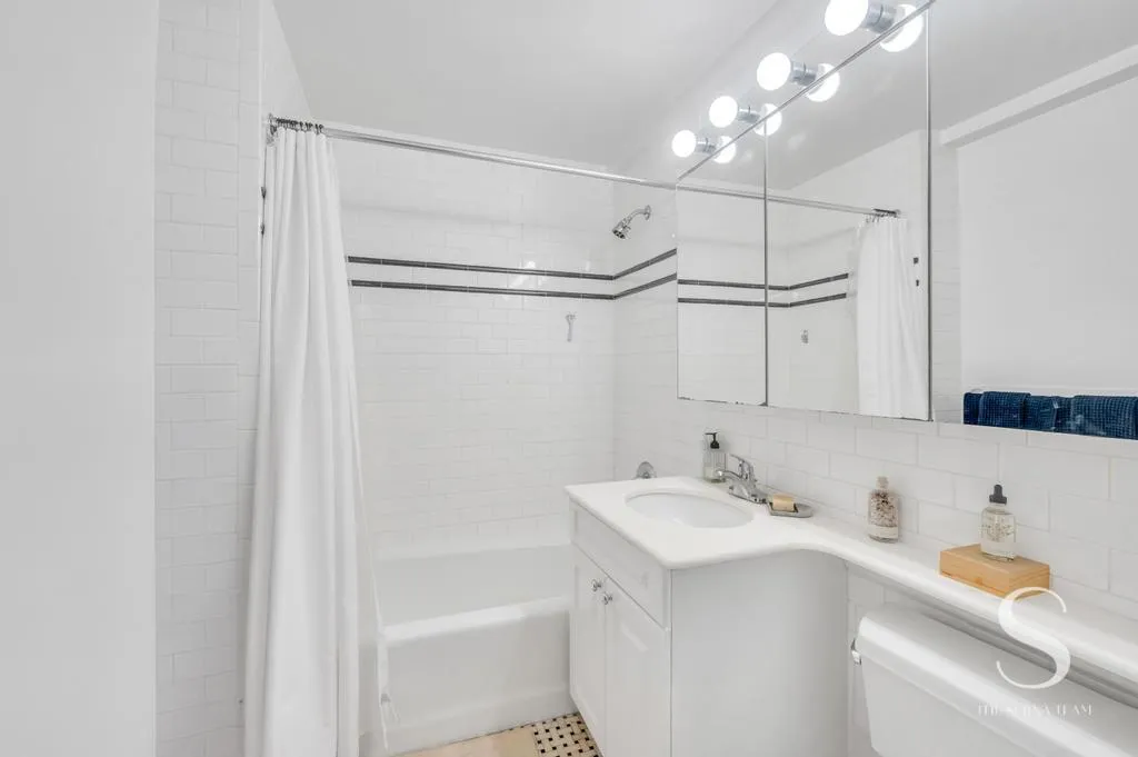 a bathroom with a sink vanity tub and shower