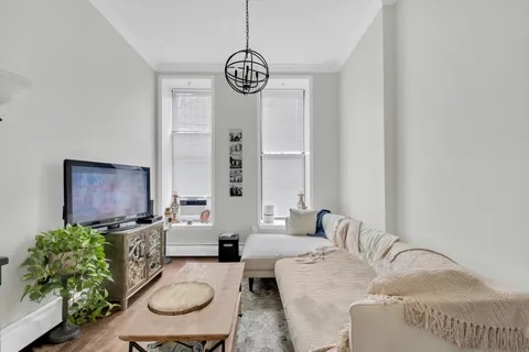 a living room with furniture a chandelier and a mirror