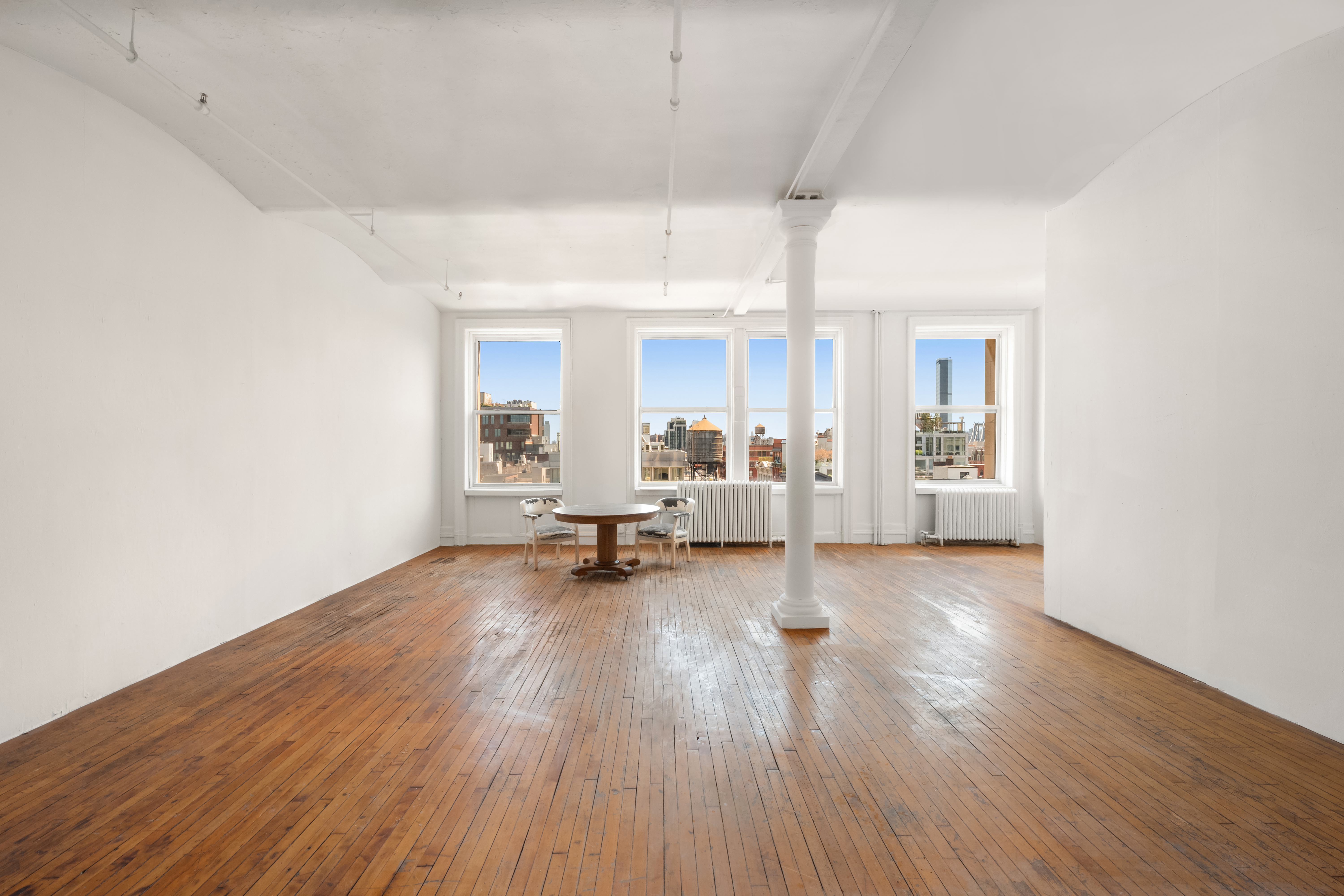 a view of a room with wooden floor and furniture