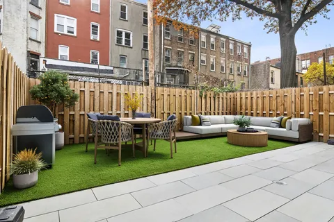 a view of a chair and tables in the patio next to a yard