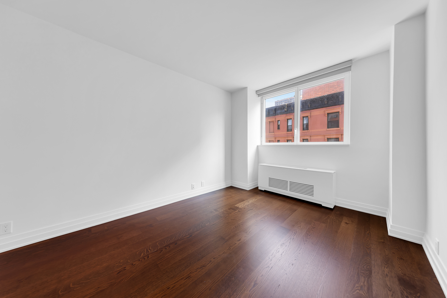 200 East 94th Street, Unit 315 Manhattan, NY 10128 - Photo 13 of 25 a view of an empty room with wooden floor and a window